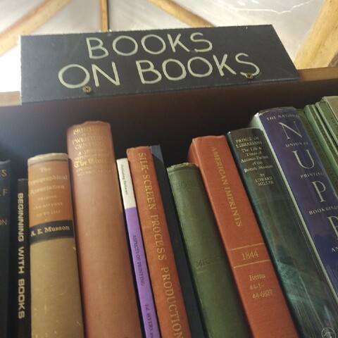 photo of a sign above a book shelve with "books on books"