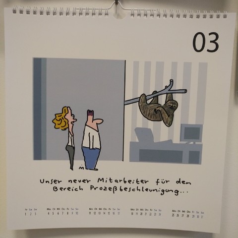 Cartoon mit einer Mann und einer Frau, die auf ein Faultier schauen, dass an einem Ast in einem Büro hängt; die Frau erläutert, was es damit auf sich hat