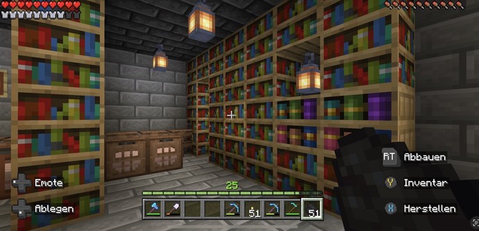 A Minecraft game screenshot showing an interior space with bookshelves, lanterns, crates, and a player's health and item inventory.
