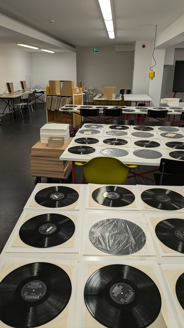 Raum, wo Schallplatten zur Trocknung auf Tischen ausgebreitet sind.