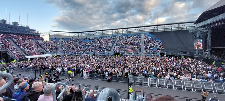 A photo of the crowded arena of Edinburgh Castle. The Esplanade is filled with people. Right the stage with Skipinnish performing.