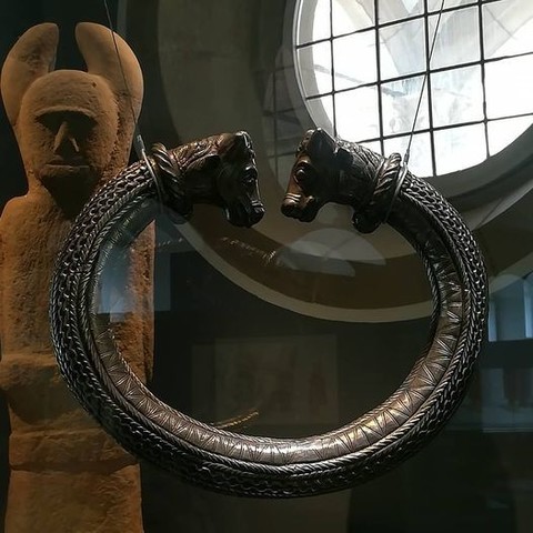 Keltischer Ring, keltische Statue und im Hintergrund ein rundes Fenster