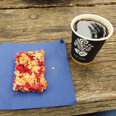 Coffee and cake on a picnic table.