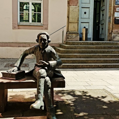 Statue of Georg Christoph Lichtenberg in front of a library building in Göttingen.

