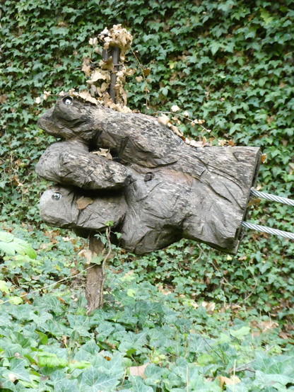 Kunst mit einer Hand aus Holz vor grünen Blättern auf dem #jergRatgeb Skulpturenpfad in #Herrenberg
