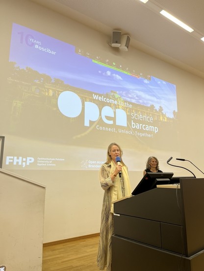 Ellen Euler from FH Potsdam is standing in front of a lantern and welcoming the participants of the Open Science Barcamp