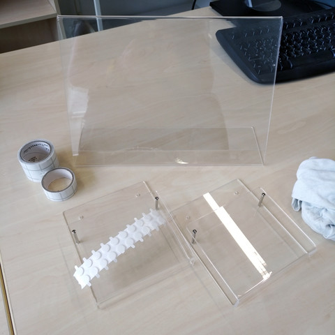 foto eines A4-plexiglas-schildhalters und zweier A6-plexiglas-prospekthalter, daneben klebepunkte und klebefolie