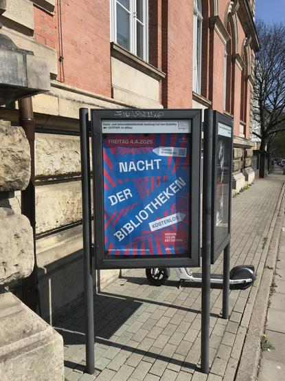 Eine Außenvitrine mit einem rot-blauen Plakat darin, mit der Aufschrift "Nacht der Bibliotheken", Freitag, 4.4.2025.

Foto: Staats- und Universitätsbibliothek Hamburg

