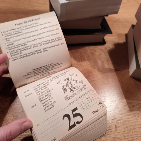 foto eines italienisch-sprachkalenders, der fest gebunden wurde, vor einem stapel weiterer kalender