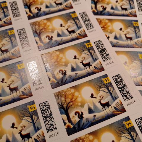 foto eines bogens von 95-cent-briefmarken der deutschen post mit einem winterlichen motiv einer schneebedeckten landschrift u.a. mit einem vogel, einem hirsch und einem eichhörnchen