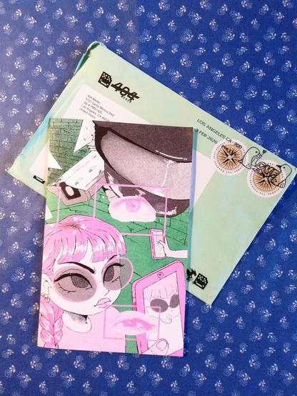 Das Zine über die Surveillance Tools von ICE liegt mit dem Versandumschlag auf einem Tisch.