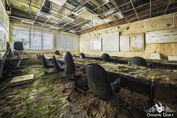 A decaying meeting room in an abandoned training center of British airways. Source: https://mstdn.social/@ObsidianUrbex/116152645209044326