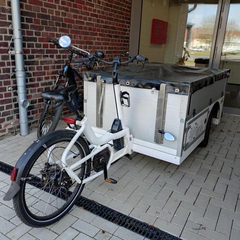 ein großes lastenrad vor einem gebäudeeingang