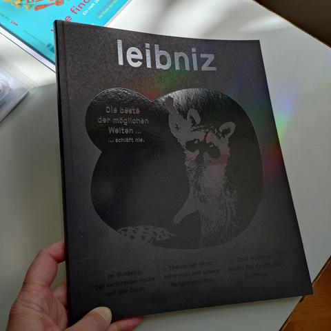 foto der vorderseite des heftes 1/2026 vom leibniz-magazin mit einer licht-reflexion im schwarz-auf-schwarz-lack für die titelzeile