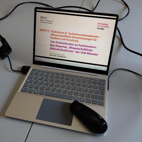 foto eines laptops mit der startfolie einer präsentation auf dem bildschirm mit folgendem titel: "WPM T2 Fachreferat und Fachinformationsdienste – Wissenschaftliche Dienstleistungen für Studium und Forschung – Von Fachreferaten zu Fachclustern: Das Dezernat "Wissenschaftliche Bibliotheksdienste" an der ULB Münster