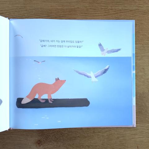 eine seite aus dem buch "바다로 간 여우": der fuchs überquert auf einer holzplanke das meer und fragt möwen um rad