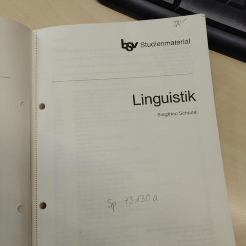 foto eins buches mit dem titel "linguistik" mit perforierten und gelochten seiten