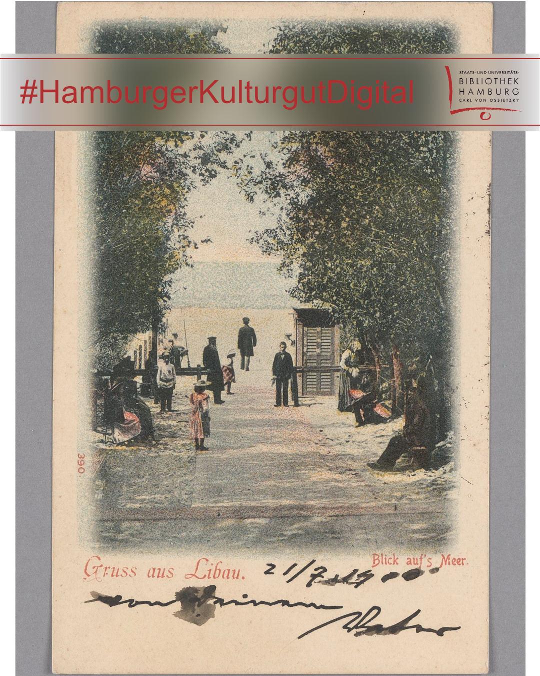 Eine kolorierte historische Postkarte zeigt eine von Bäumen gesäumte Promenade, die auf das Meer zuführt. Menschen in zeittypischer Kleidung spazieren oder stehen auf dem Weg, einige sitzen auf Bänken. Im Hintergrund ist das Wasser zu sehen. Am oberen Rand befindet sich ein halbtransparenter Balken mit dem Hashtag 'HamburgerKulturgutDigital' und dem Logo der Stabi Hamburg. Unten auf der Karte steht der Text 'Gruss aus Libau. Blick aufs Meer.' sowie eine handschriftliche Notiz.