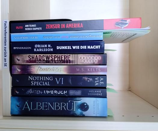 foto einiger bücher in einem regalfach; zu besseren lesbarkeit der titel auf den buchrücken wurde das foto um 90 grad nach rechts gedreht