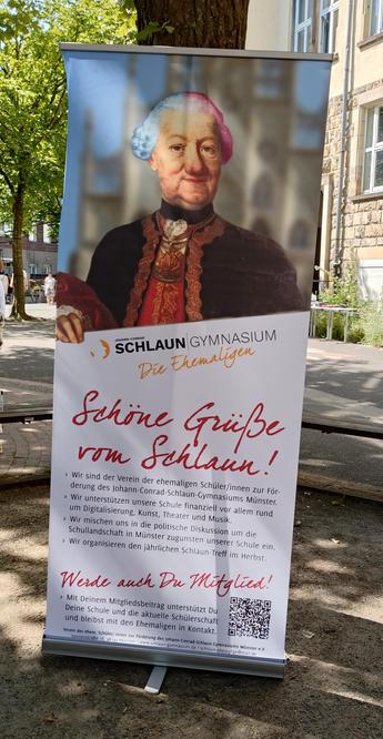 foto eines roll-ups des ehemaligen-vereins des johann-conrad-schlaun-gymnasiums in münster, aufgestellt auf dem schulhof