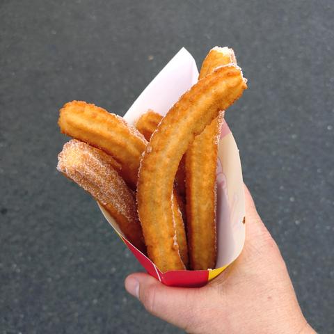 foto einer portion churros mit zucker in einer papiertüte