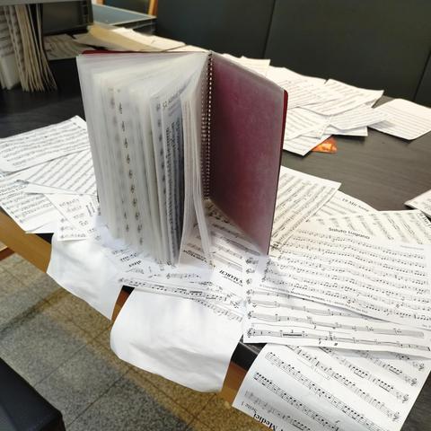 foto eines noten-marschbuches, aus dem zahlreiche noten herausgenommen worden sind, damit sie trocknen können