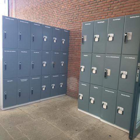 foto einiger der schließfächer für die bibliothek im vom-stein-haus der uni münster; die fächer tragen namen von filmen, stilmitteln und autor:innen