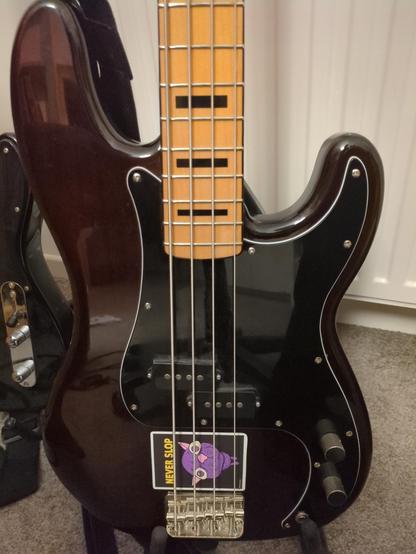 Precision bass with #neverslop kitty sticker next to the bridge